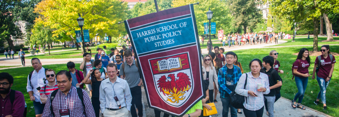 CAPP and Harris students walking on campus quad with Harris banner